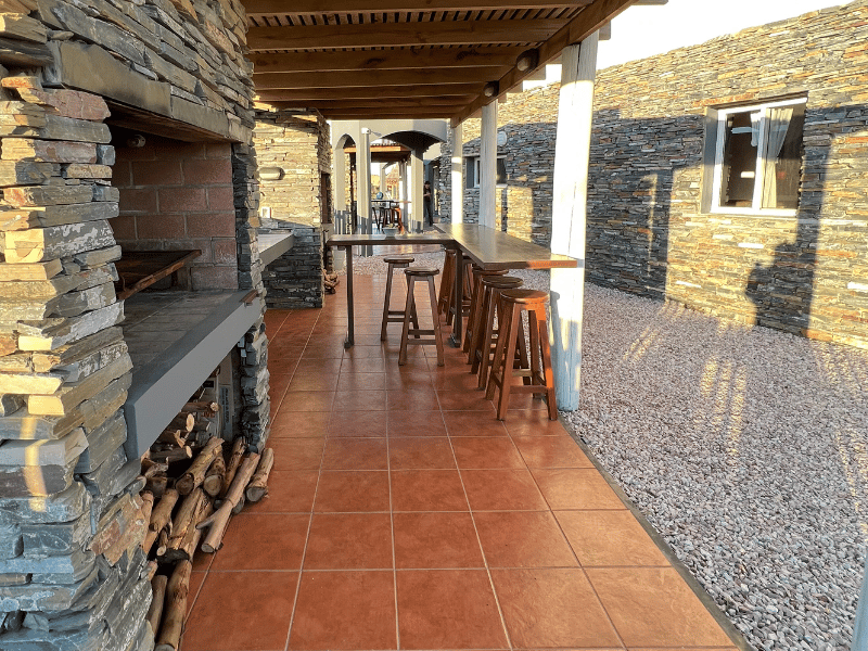 A stone wall with a table and stools in front of it