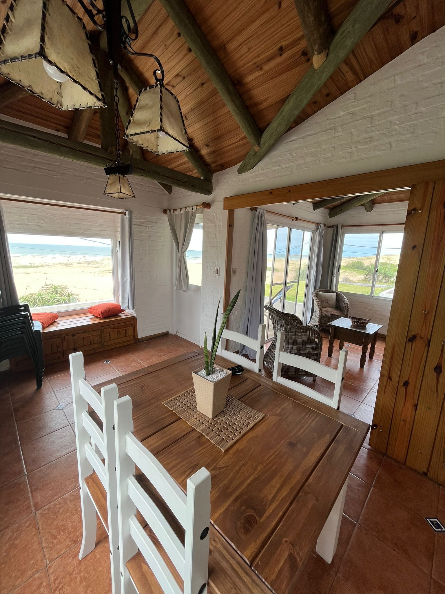 A wooden table with white chairs in a living room.