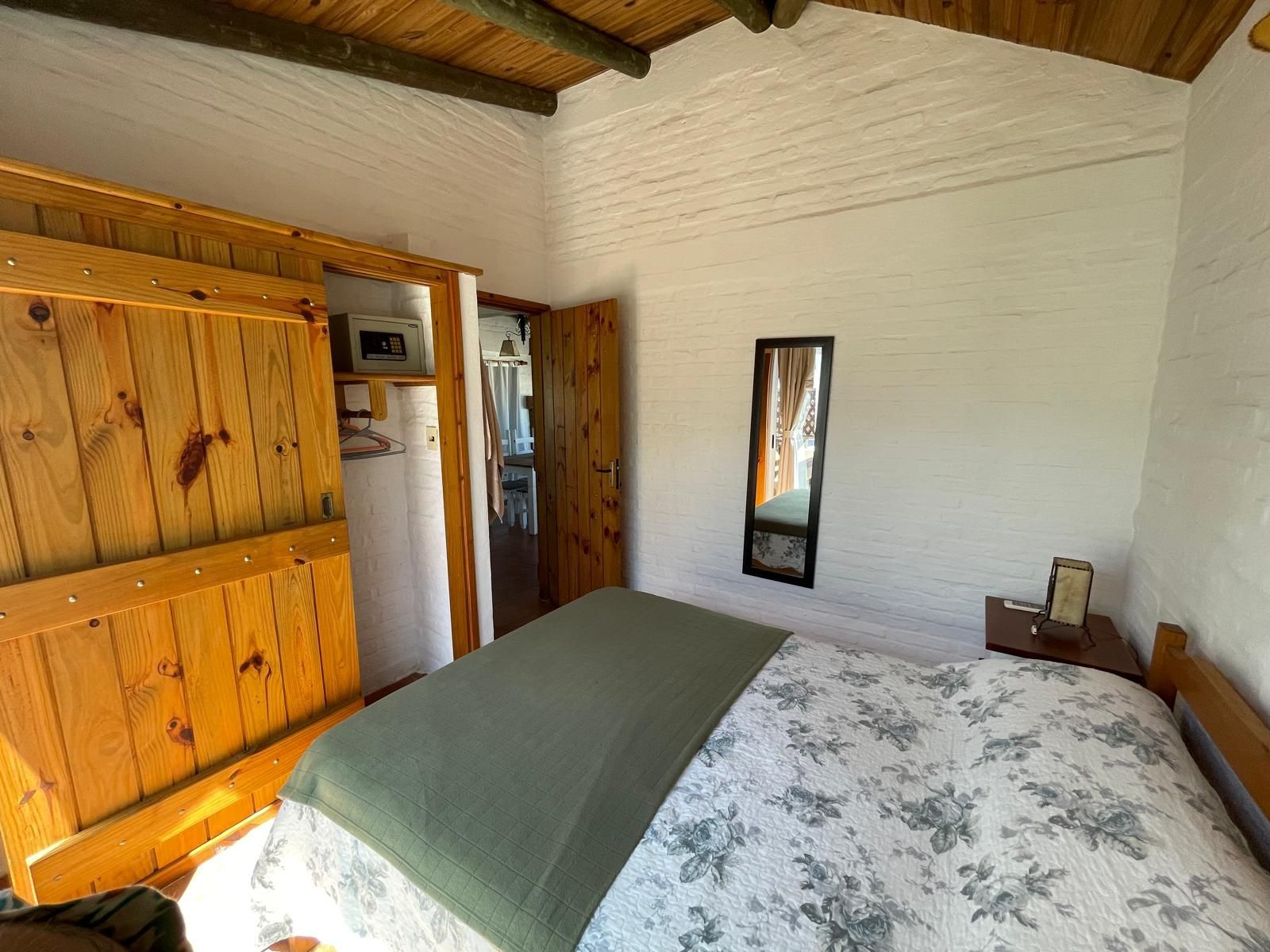 A bedroom with a bed and a mirror on the wall.