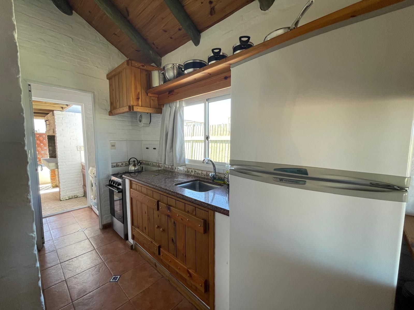 A kitchen with wooden cabinets and a white refrigerator