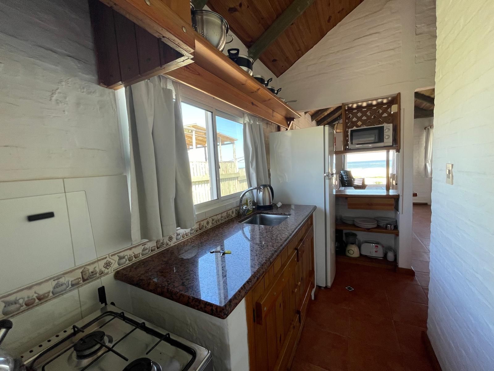 A kitchen with a stove , sink , and microwave