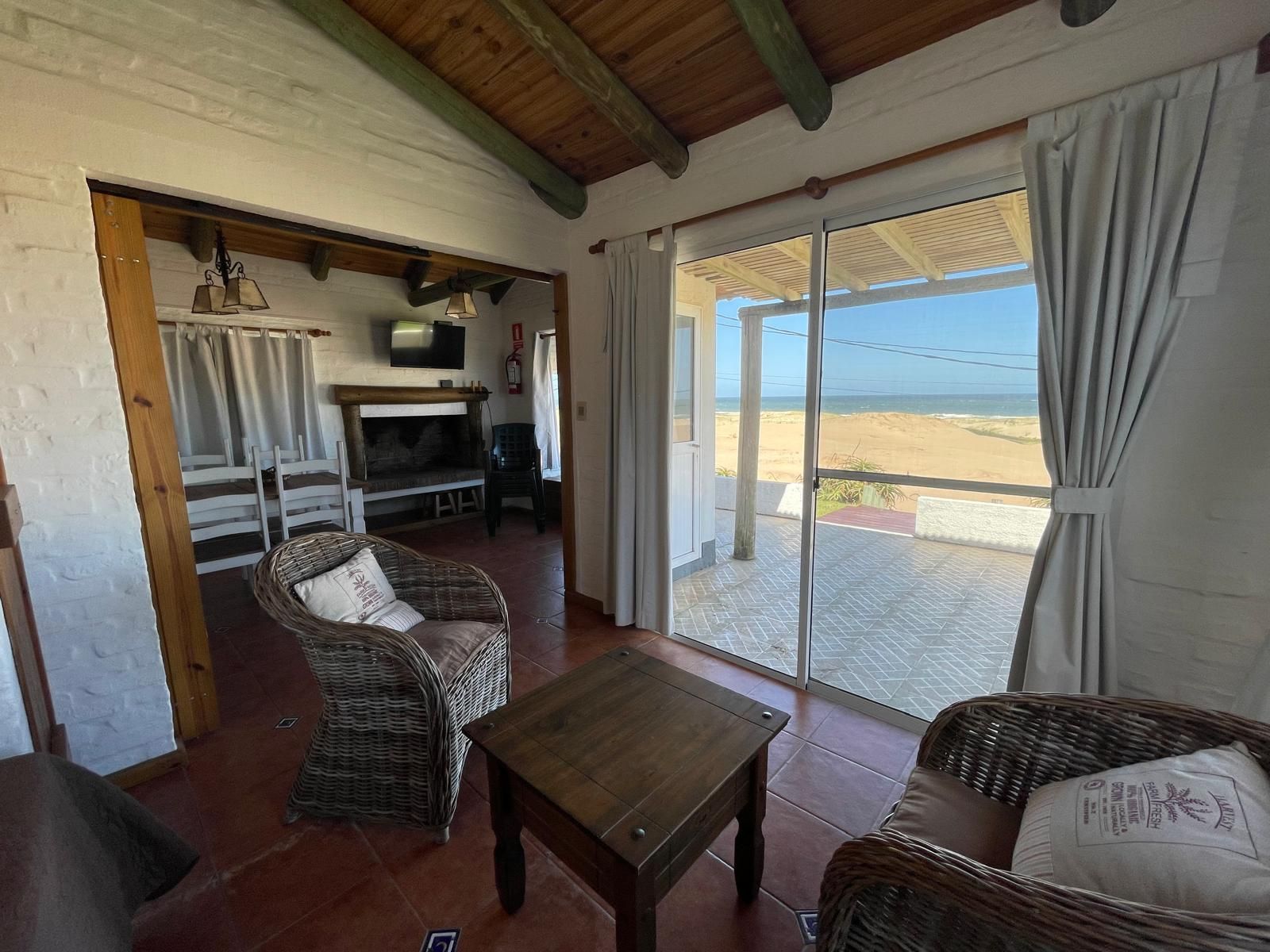 A living room with a sliding glass door leading to the beach.