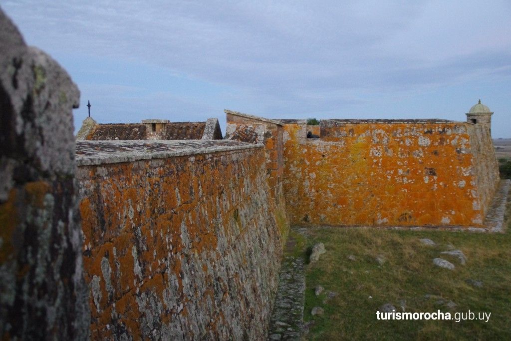 A large stone wall with a blue sky in the background
