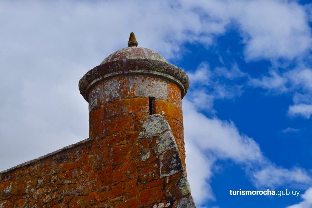 A brick tower with a blue sky in the background