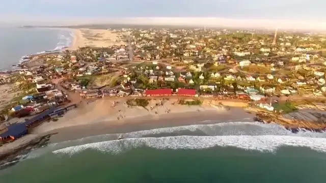 An aerial view of a beach with a city in the background.