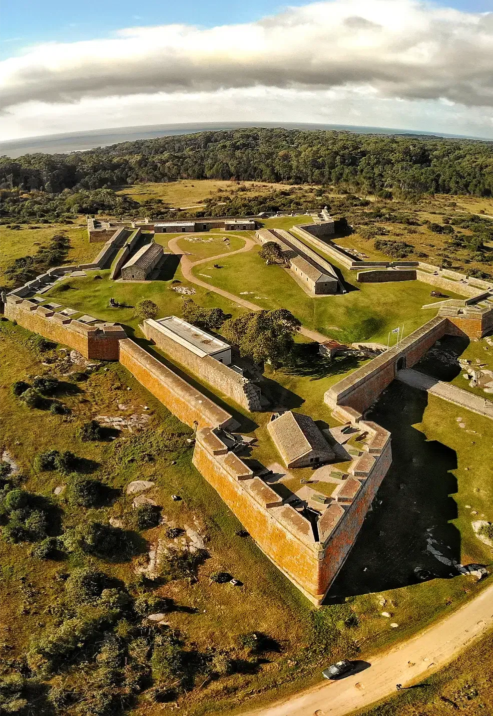 An aerial view of a large castle surrounded by grass and trees.