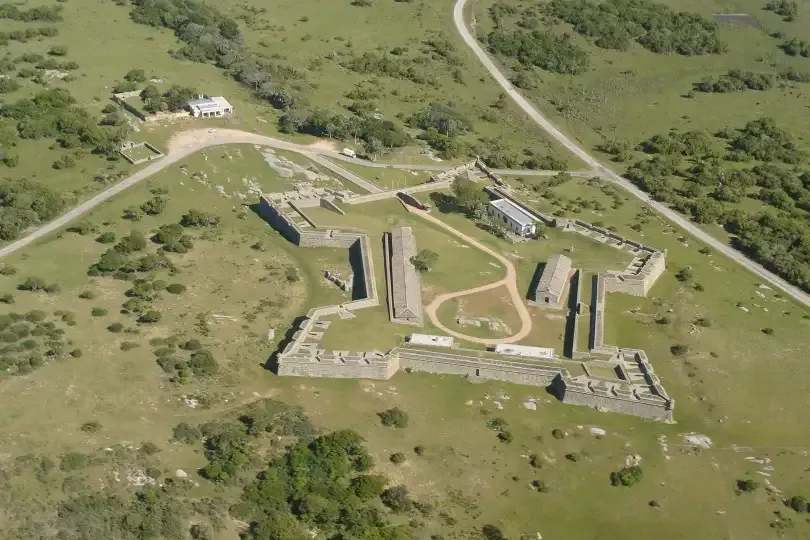 An aerial view of a castle in the middle of a grassy field