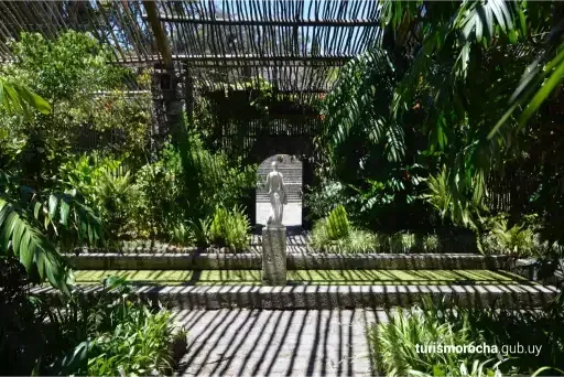 A lush green garden with a statue in the middle