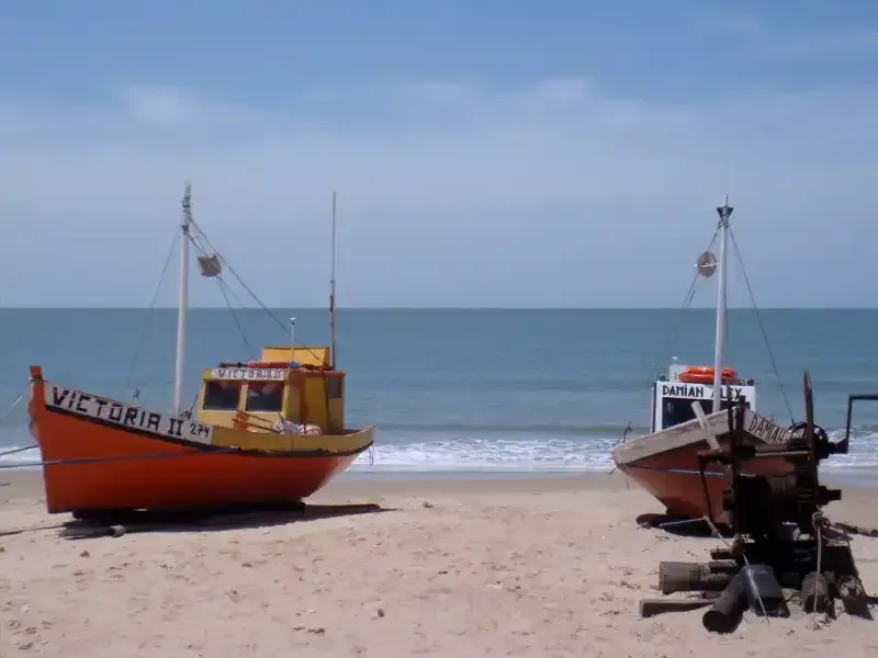 Two boats on the beach one of which has the name victoria on it