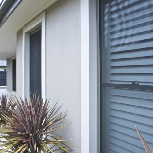Side View of a House Wall With Cream-colored Siding — Suburban Security Screens in Currumbin, QLD