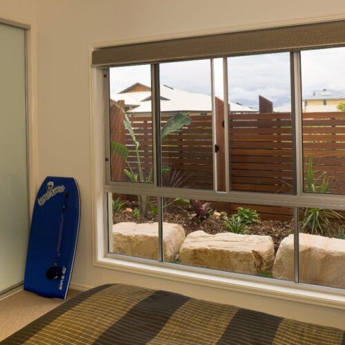 Room With a Blue Bodyboard Propped — Suburban Security Screens in Currumbin, QLD