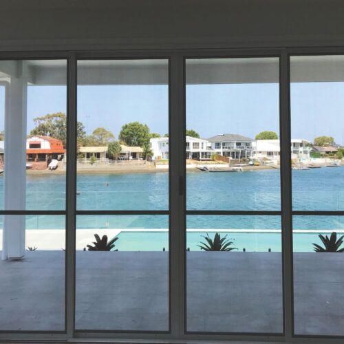 View Through Floor-to-ceiling Glass Doors Showing a Patio — Suburban Security Screens in Currumbin, QLD