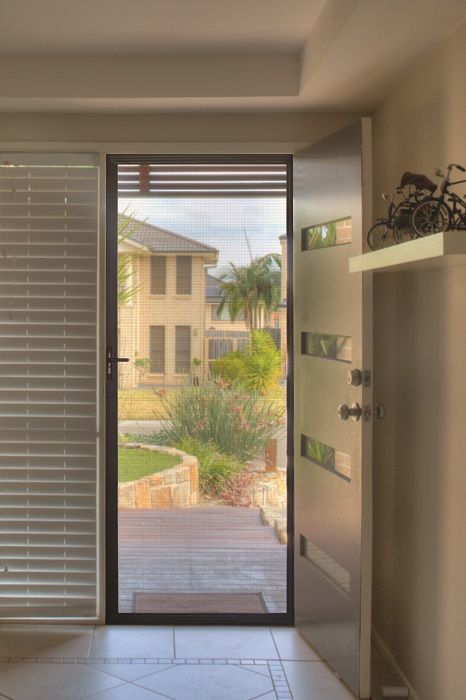 An Open Door with A Screen Door Looks out Onto a Suburban Home — Suburban Security Screens in Currumbin, QLD