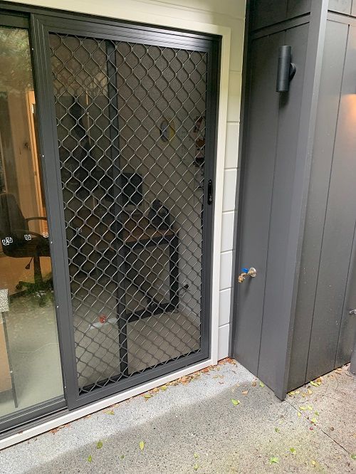 A Sliding Glass Door with A Dark Grey Security Screen — Suburban Security Screens in Currumbin, QLD