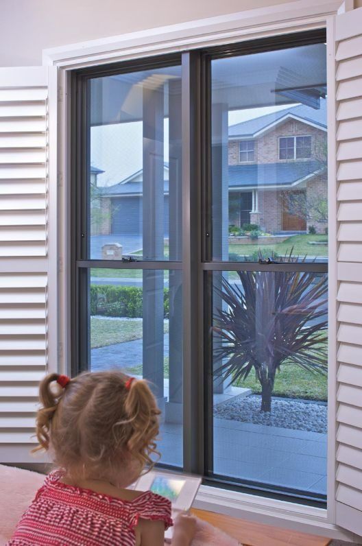 Child With Pigtails Plays on a Tablet — Suburban Security Screens in Currumbin, QLD