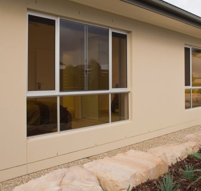 Beige House Exterior With White-framed Windows — Suburban Security Screens in Currumbin, QLD