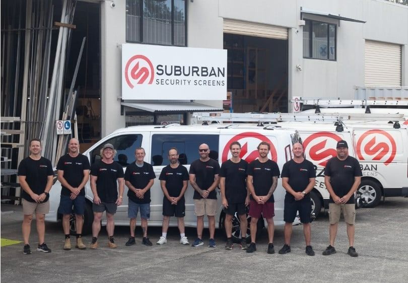 Group of Eleven People Standing in Black Uniforms — Suburban Security Screens in Currumbin, QLD