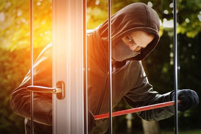 A Person Uses a Red Pry Bar to Force Open a Glass Door — Suburban Security Screens in Currumbin, QLD