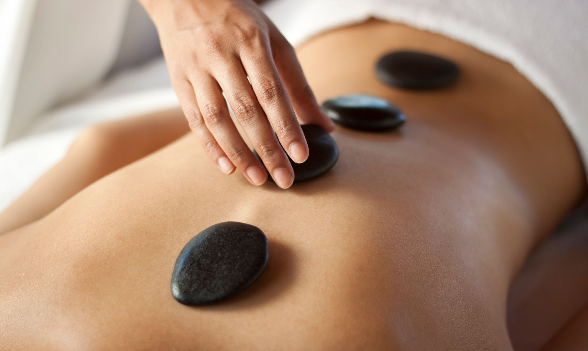 A woman is getting a hot stone massage at a spa.
