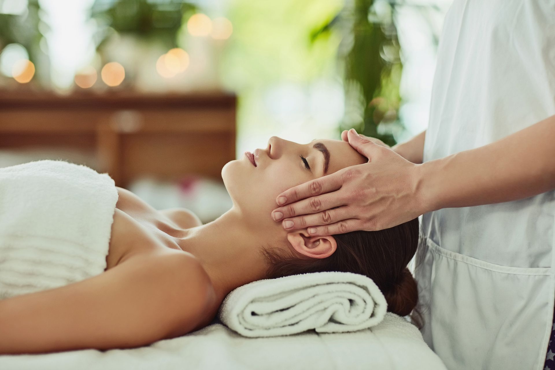 A woman is getting a head massage at a spa.
