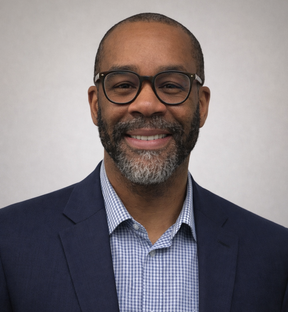 Male with glasses smiling with a beard and mustache