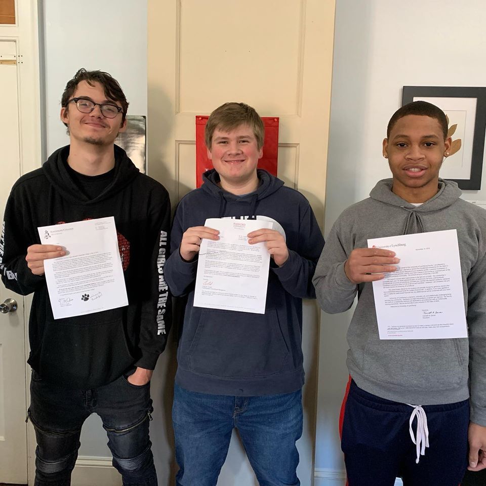Smiling image of a three young male holding papers