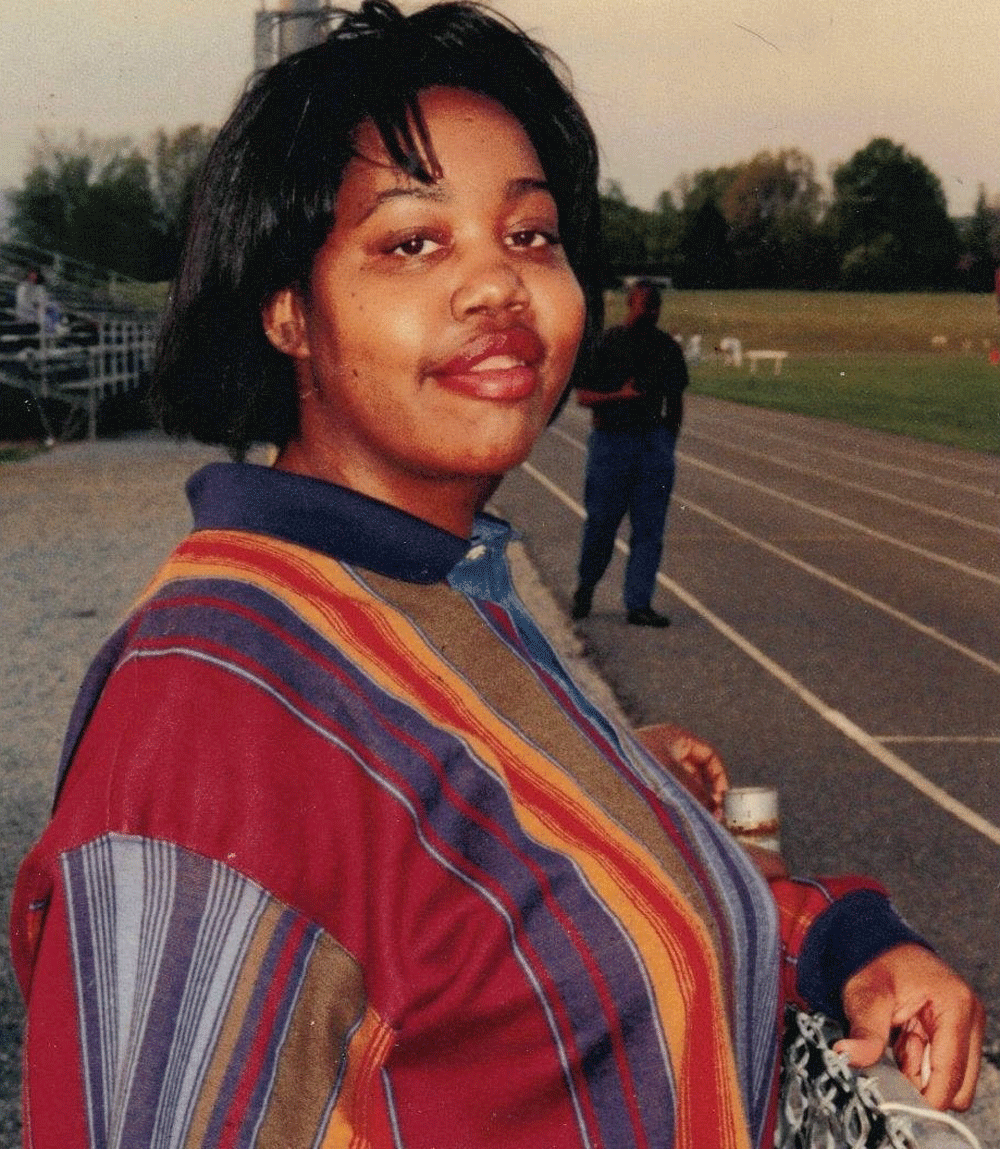 Female in a stripped shirt standing on a running track