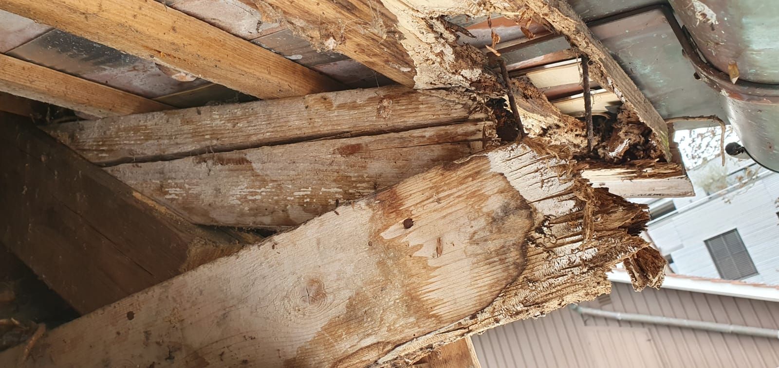 Eine Nahaufnahme eines Holzbalkens in einem Gebäude.
