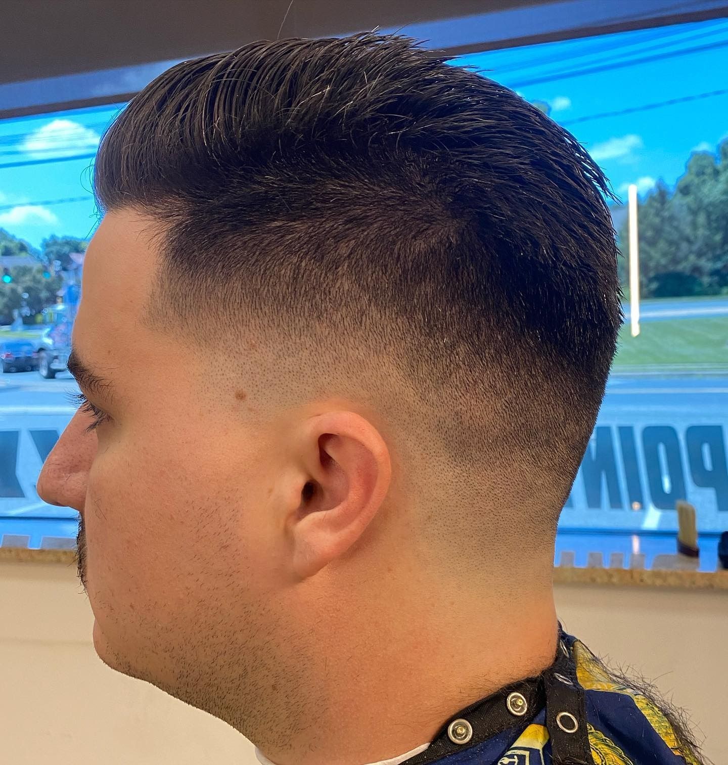 A man is getting his hair cut at a barber shop