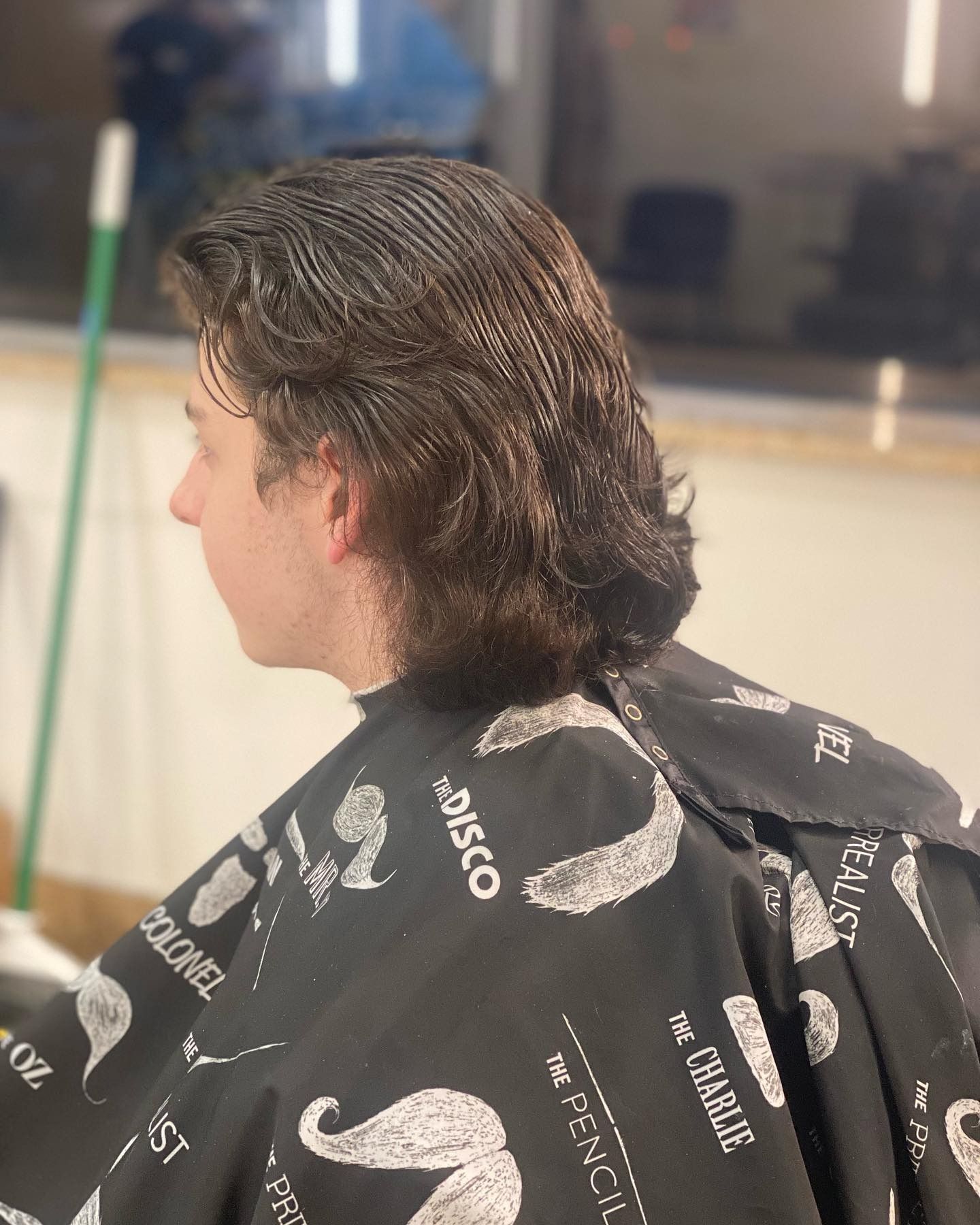 A man is getting his hair cut in a barber shop.