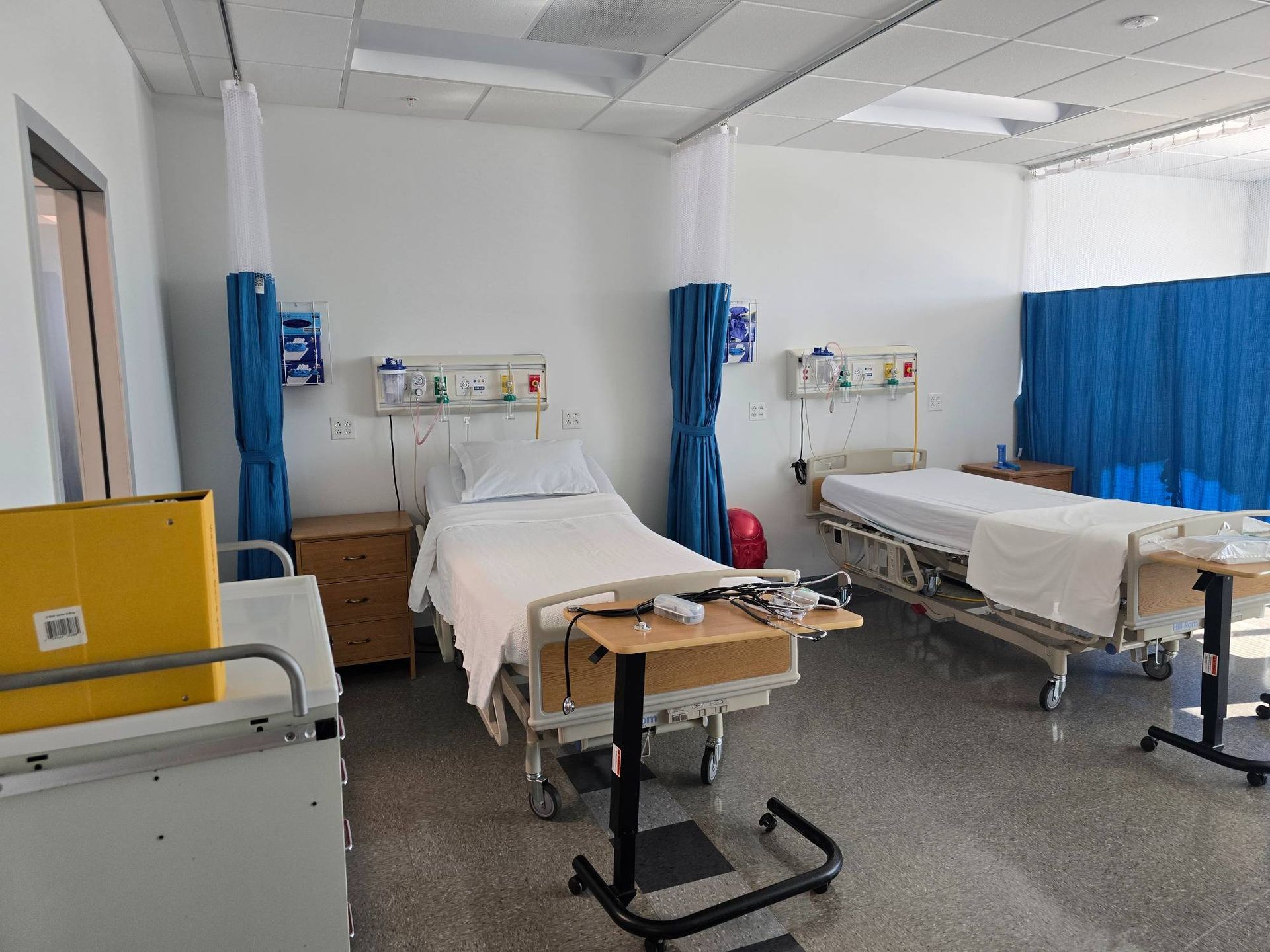 A hospital room with two beds and a table.