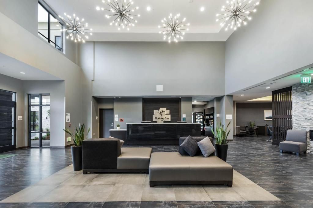 A large lobby of a hotel with a couch and chairs