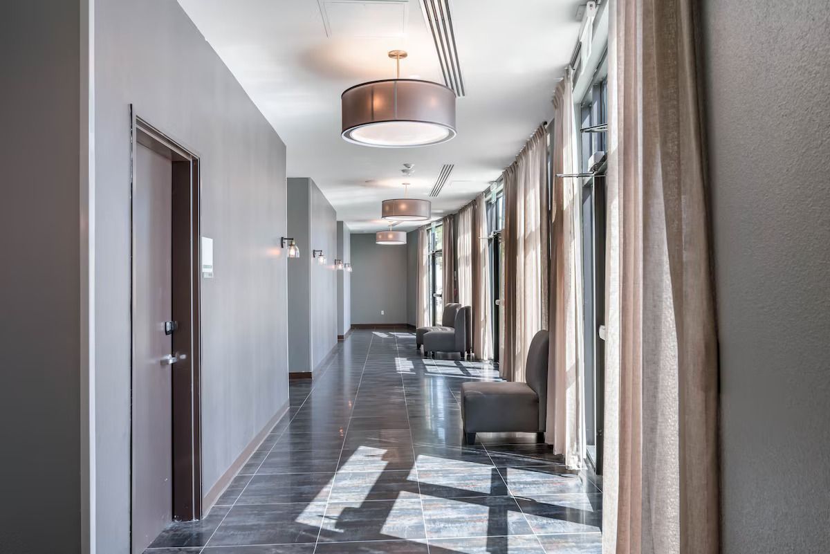 A long hallway with a lot of windows and chairs.