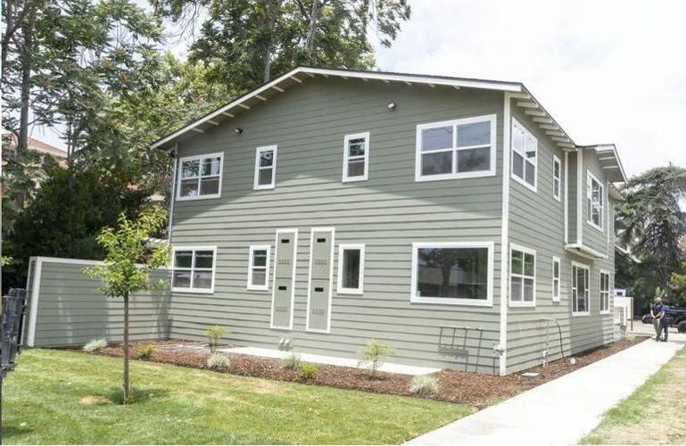 A house with a lot of windows and a sidewalk in front of it