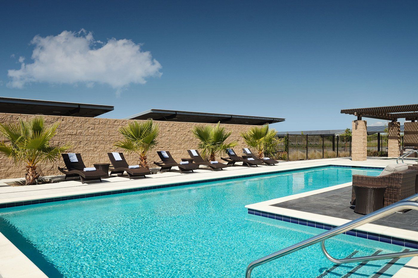 A large swimming pool with chairs and umbrellas around it