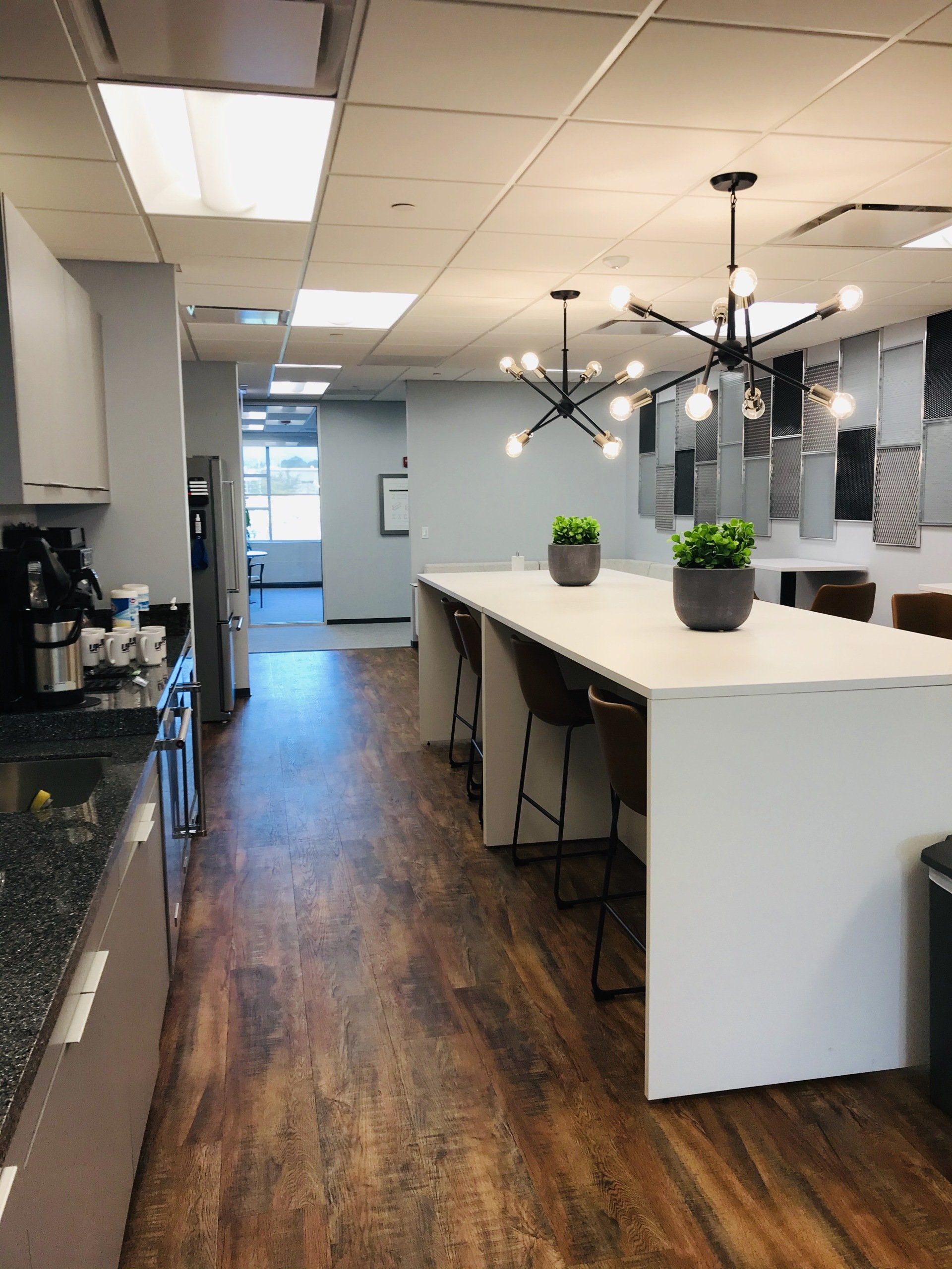 A kitchen with a long white table and stools