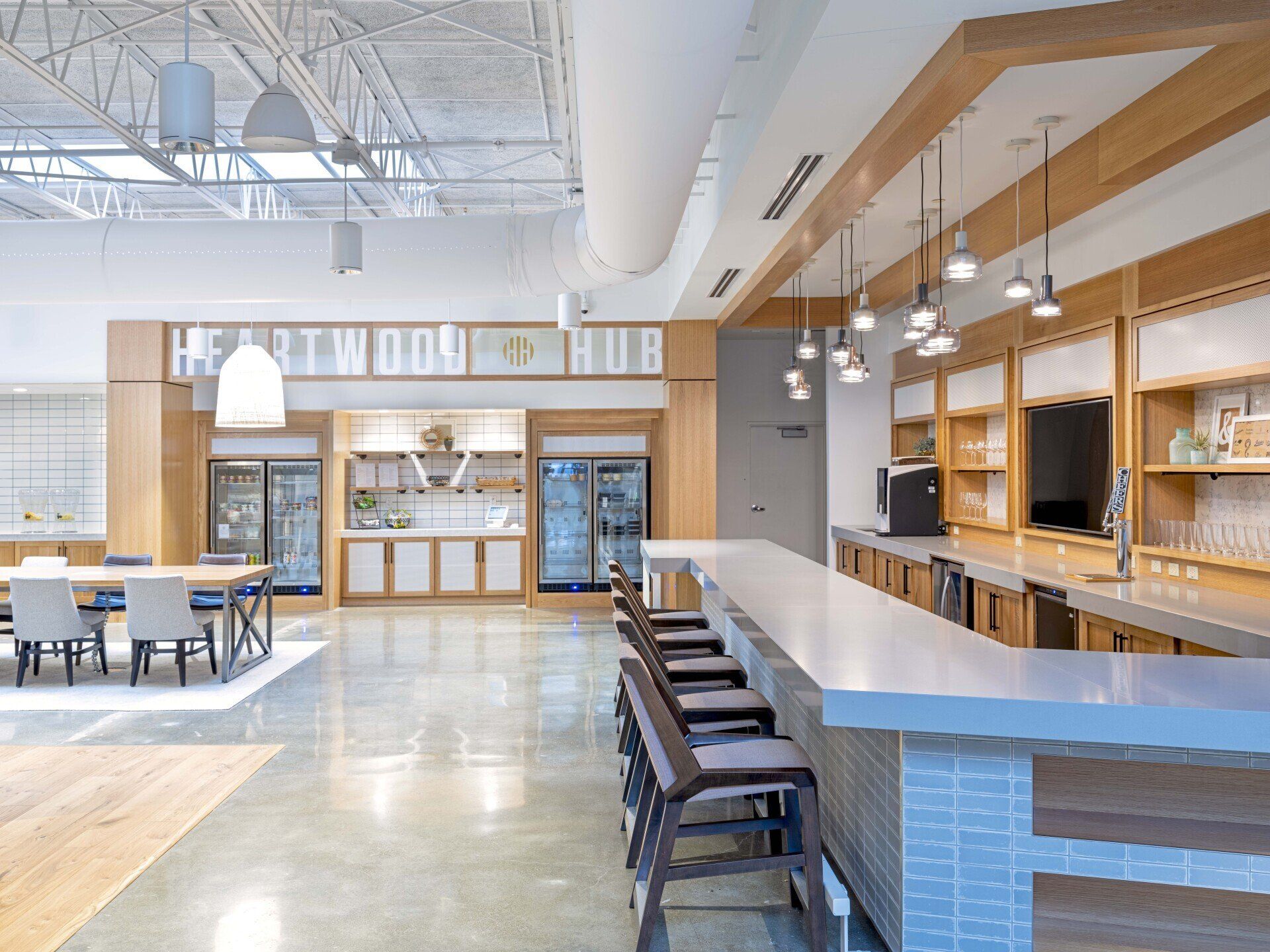 A large room with a long bar and a sign that says heartwood hub