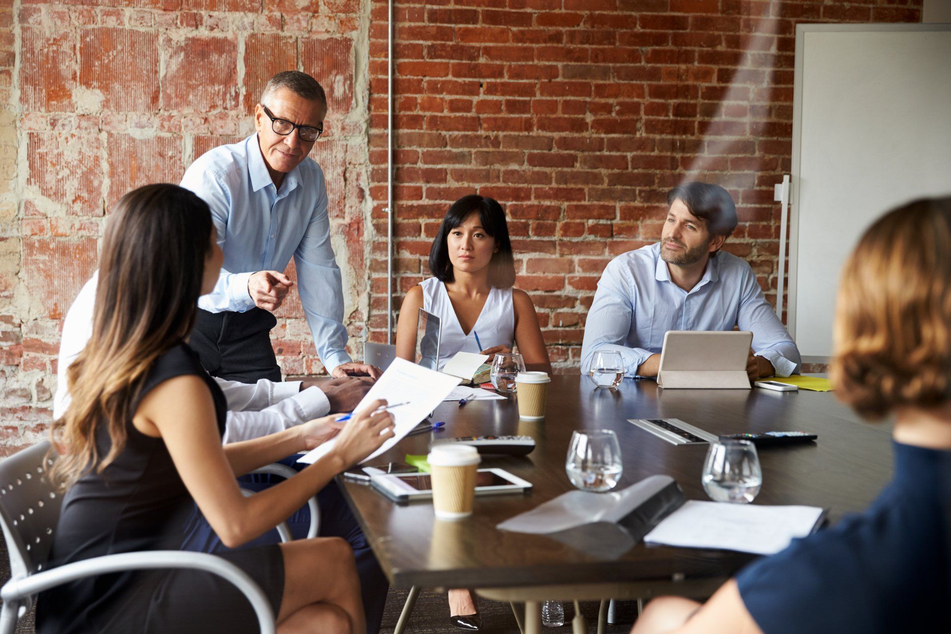 A group of people are sitting around a table having a meeting.