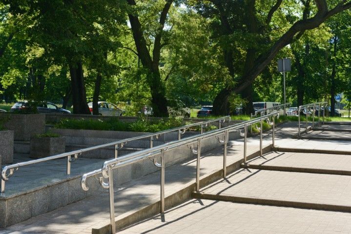 Ramp with metal handrails next to stairs