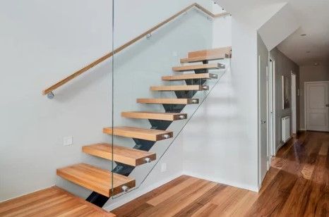 Stylish wooden staircase with glass railings