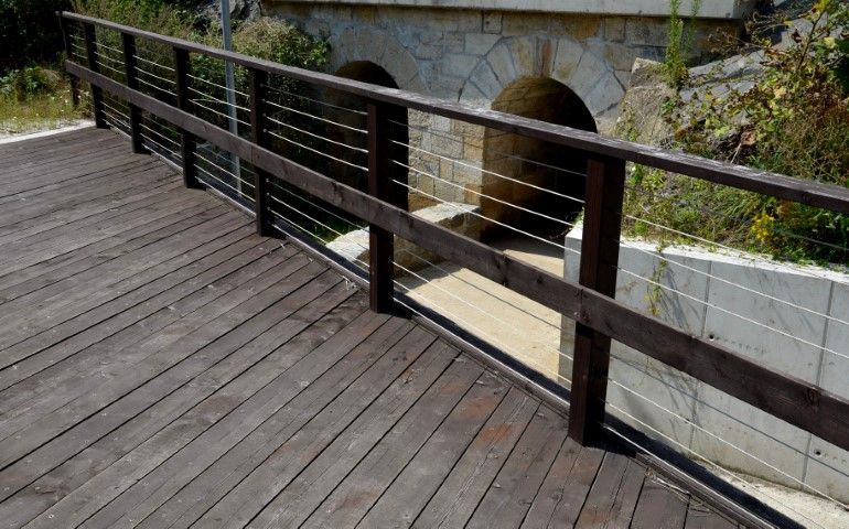 Wood walkway with stainless railing spanning a creek