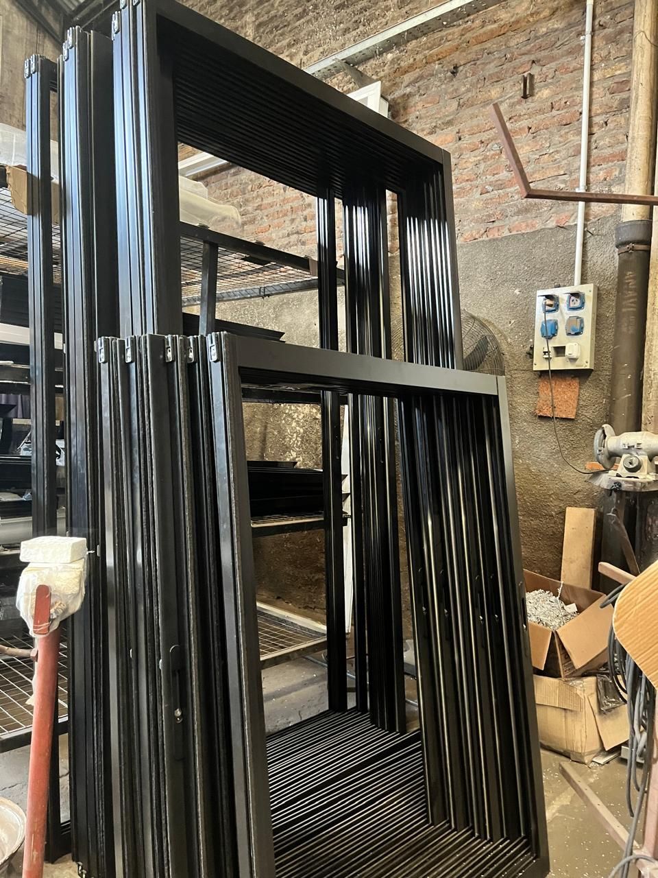 Un montón de marcos de aluminio están apilados uno encima del otro en un almacén.