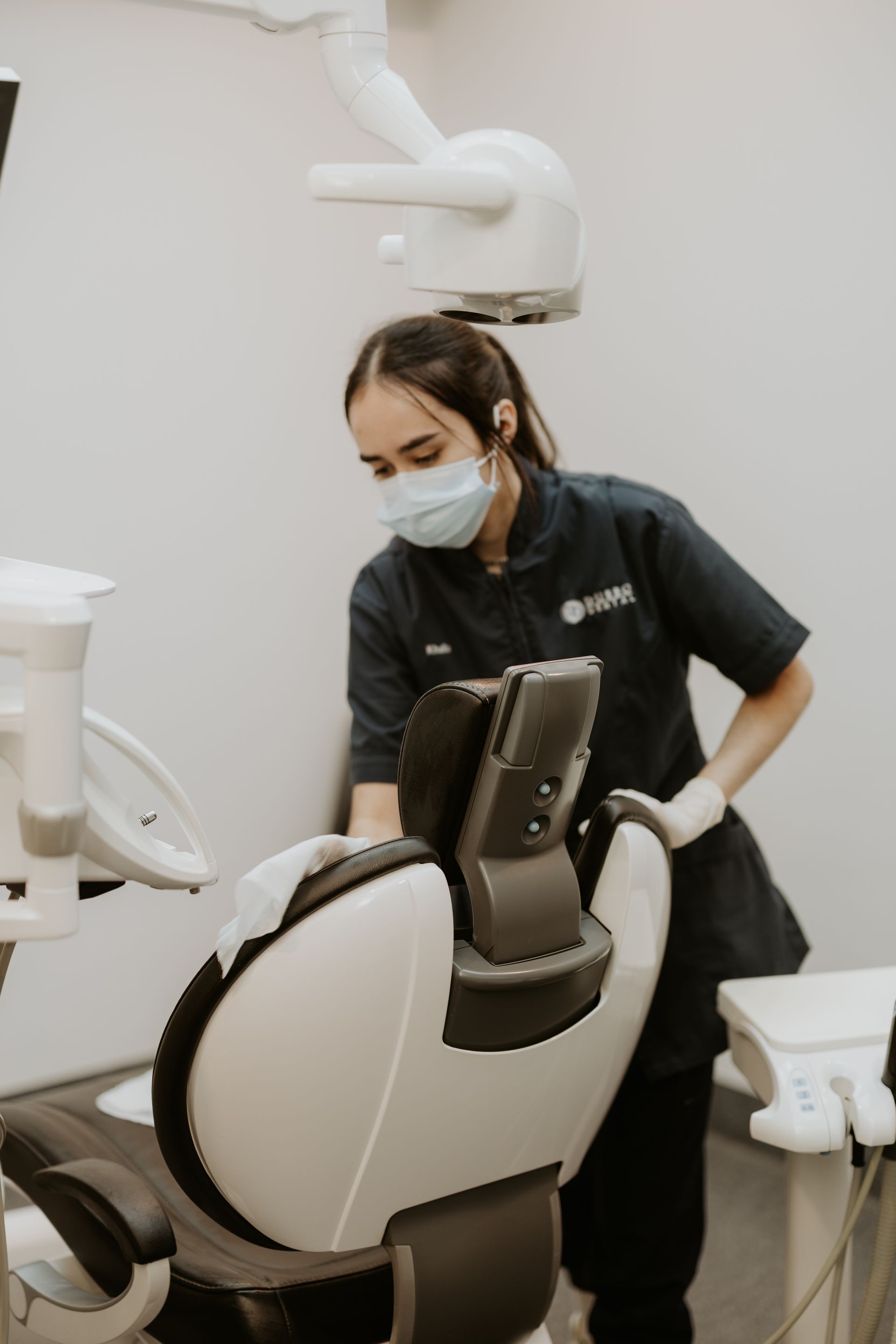Dental Assistant Cleaning a Dental Chair in an Examination Room — Dubbo Dental in Dubbo, NSW