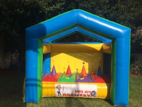 Inflatable archery game with colorful targets, blue frame, and yellow interior, on grass.