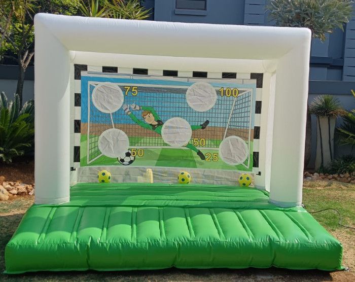 Inflatable soccer goal game with targets, green and white, outdoors.