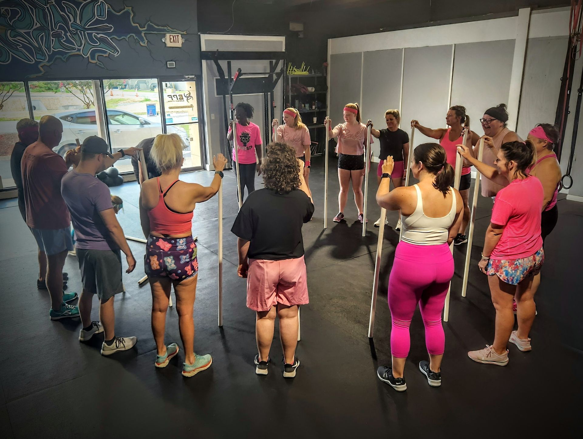 A group of women are standing in a circle in a gym.