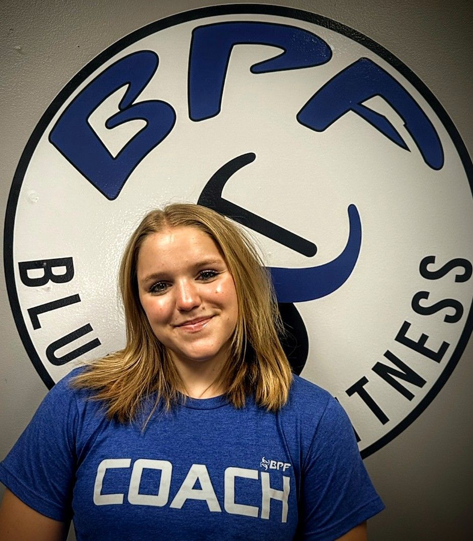 A woman wearing a blue shirt that says coach on it