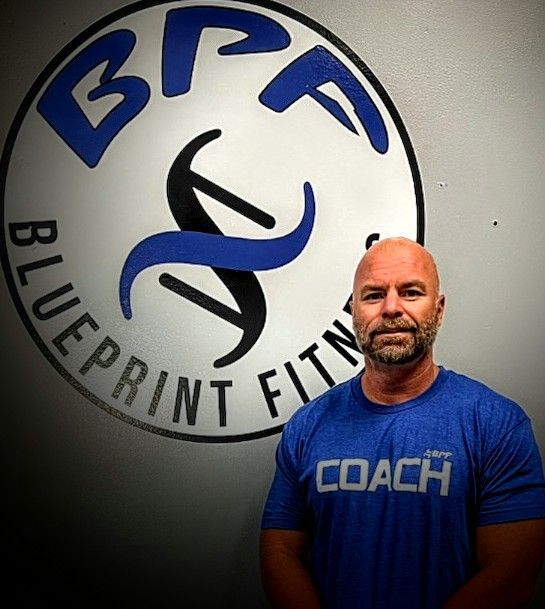 A man wearing a blue shirt with the word coach on it