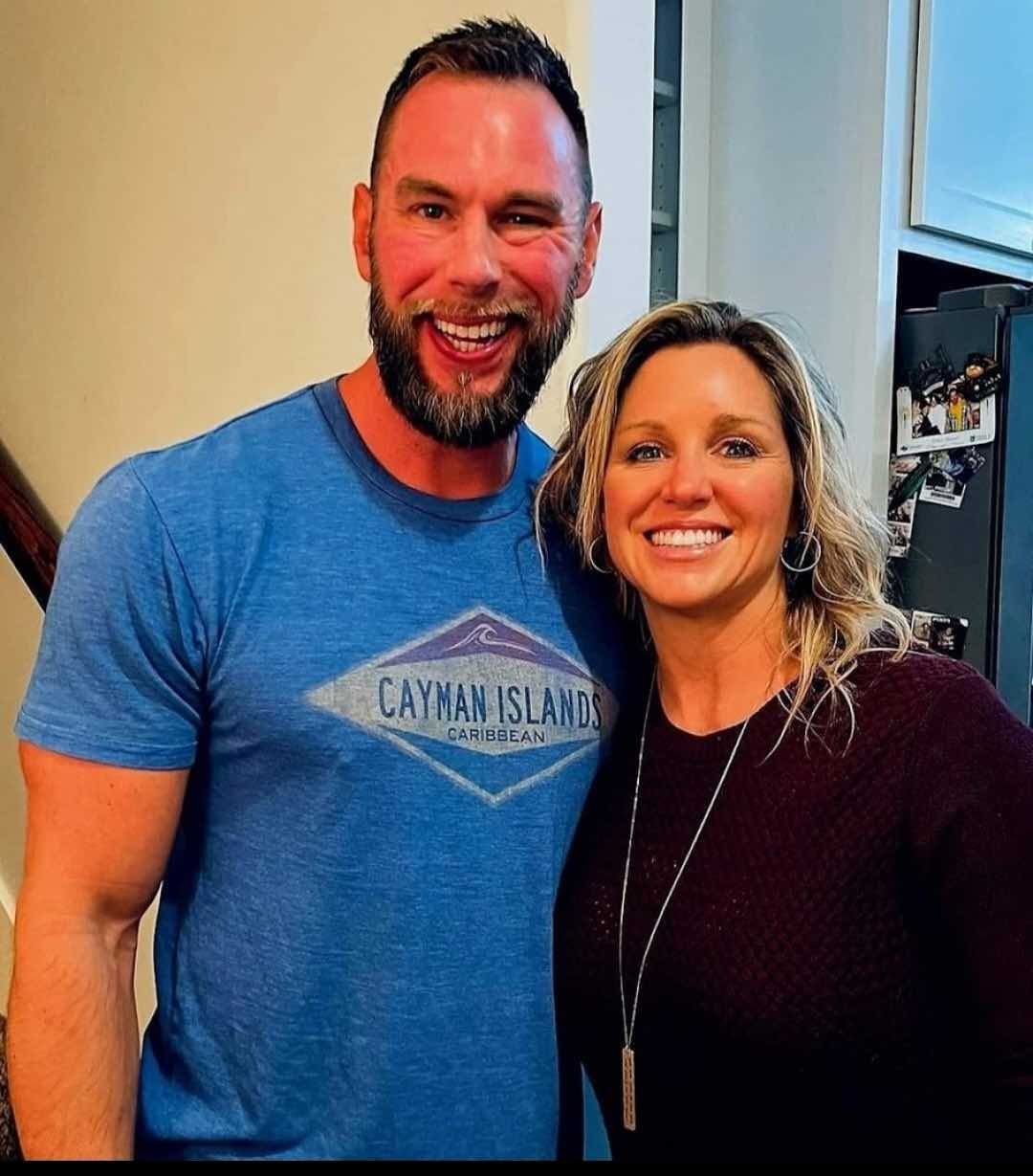 A man wearing a cayman island shirt poses with a woman