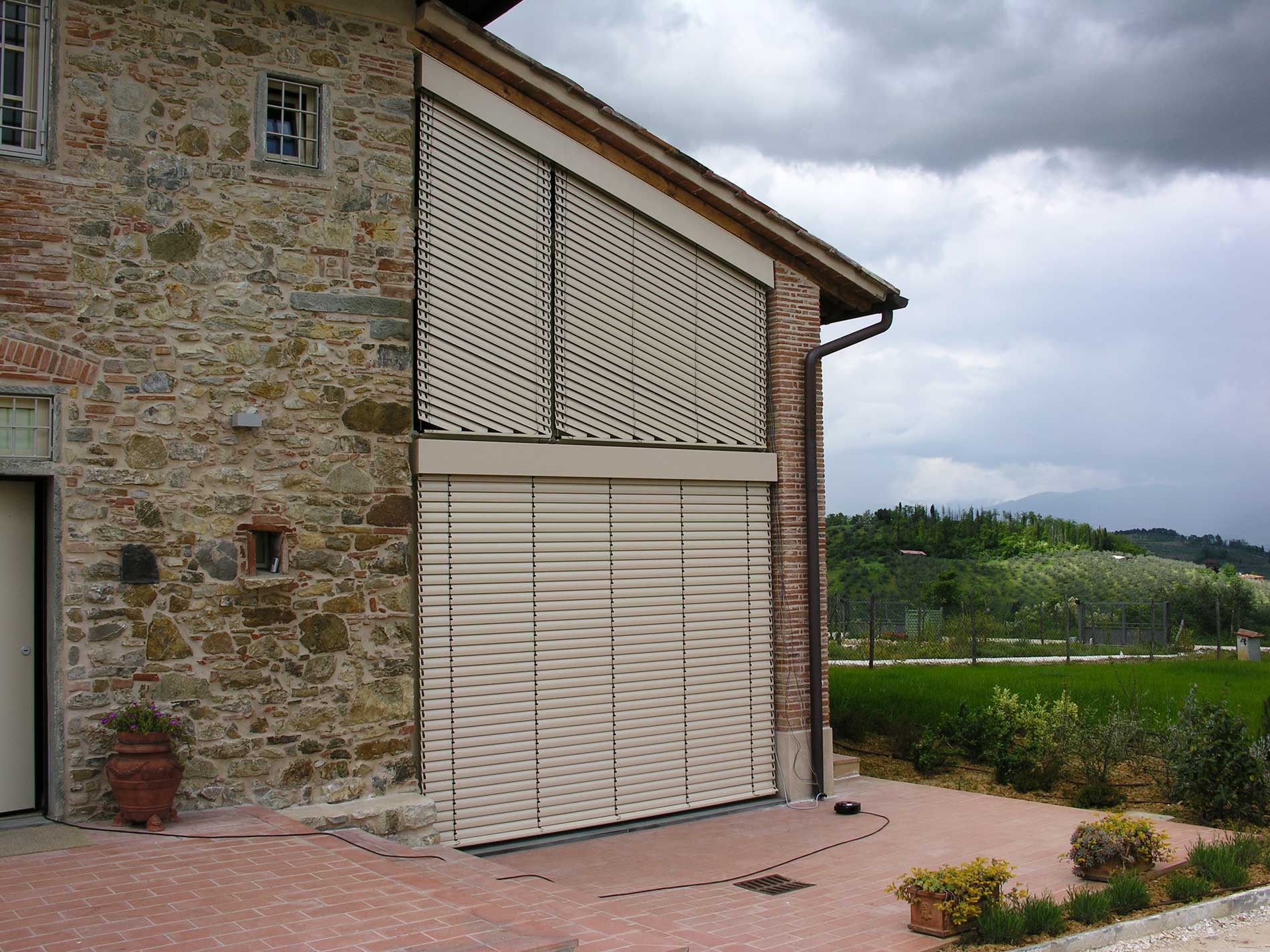Edificio in pietra con porta scorrevole beige e pannelli a graticcio